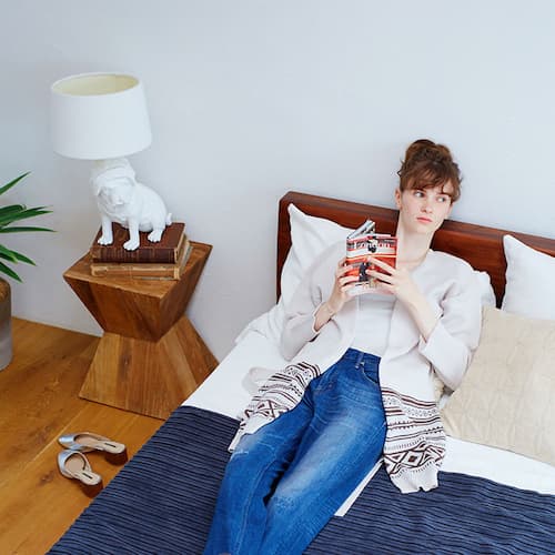 ベッドで読書する女性